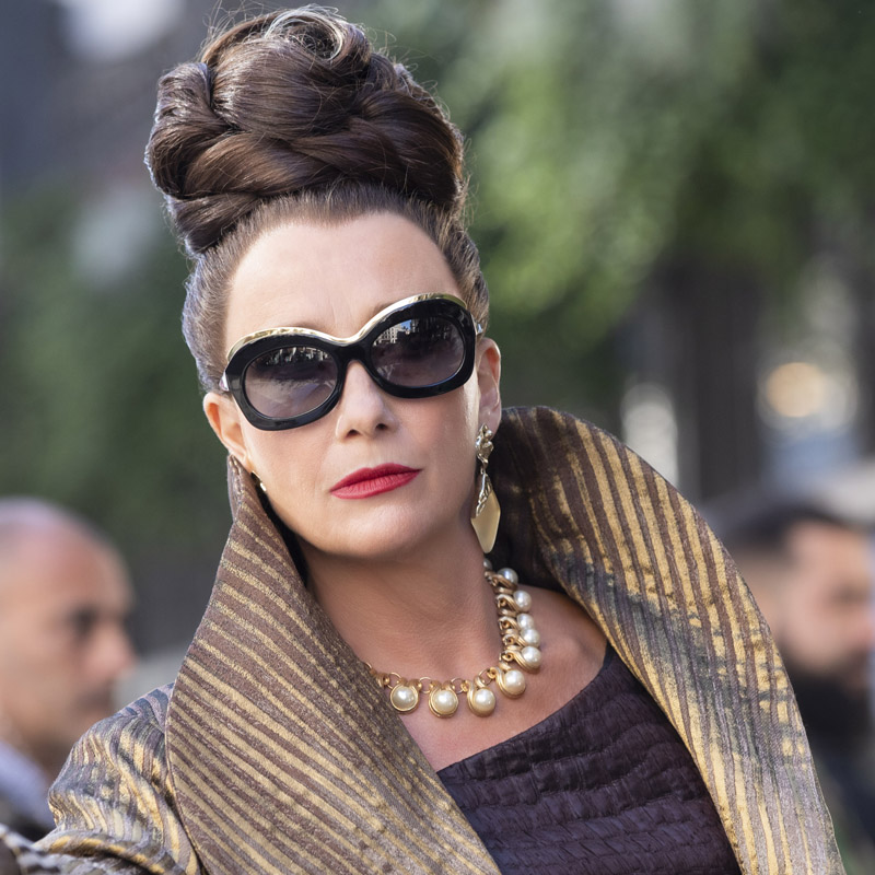 Emma Thompson as The Baroness wears sunglasses in Disney's Cruella, designed by Tom Davies.