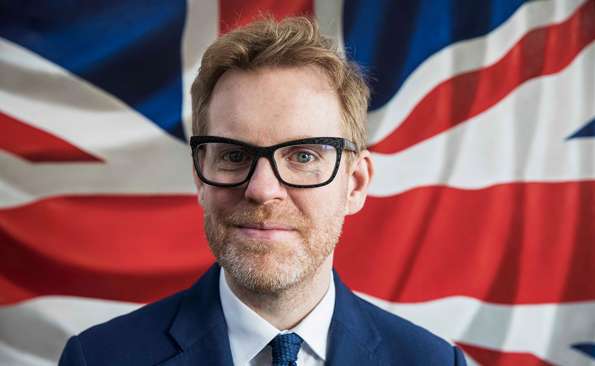British eyewear designer Tom Davies in front of the Union Jack