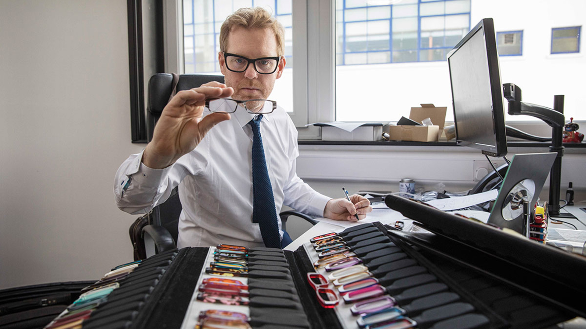 British eyewear designer Tom Davies examining acetate colour options in his London office