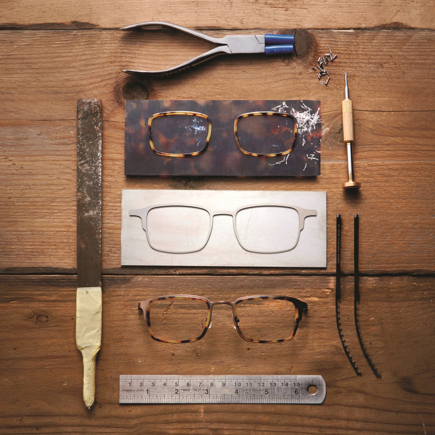 Workbench with parts of titanium frame and tools in the Tom Davies London factory